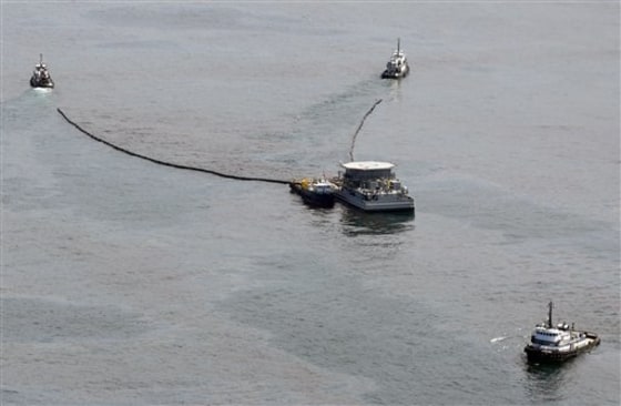 Tug boats pull a tank, center, containing oil and water skimmed from the surface of the Gulf of Mexico near the coast of Louisiana on Friday.